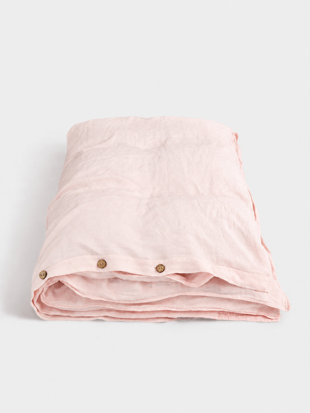 Rosewater pure linen duvet cover — folded with coconut buttons